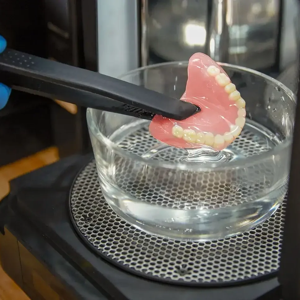 lucrare printata 3D cu denture baase si premium teeth in solutie de curatare