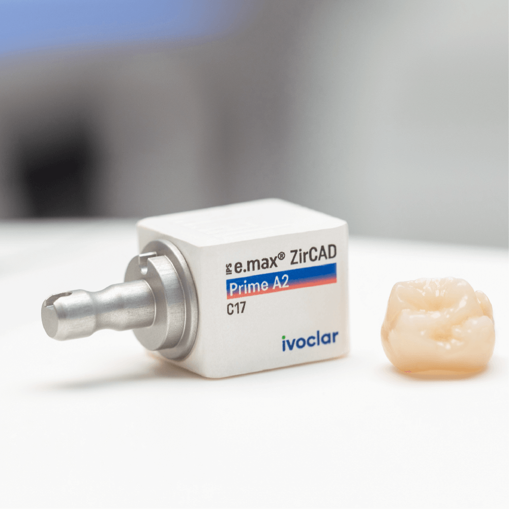 lucrare realizata cu IPS e.max zirCAD prime in laboratorul de tehnica dentara si blocul de ceramica asezat langa