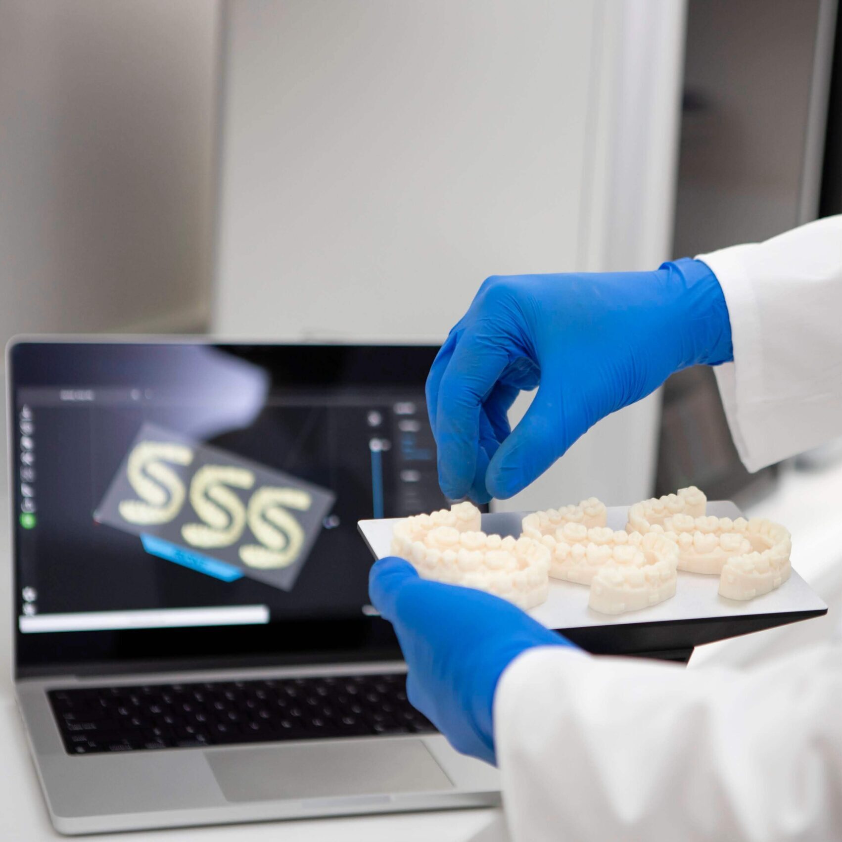 tehnician dentar ridicand modelele realizate cu imprimanta 3D nexa 3D xip